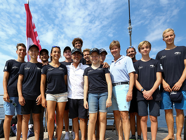 CEO Mark Watson and young sailors standing on a sailboat