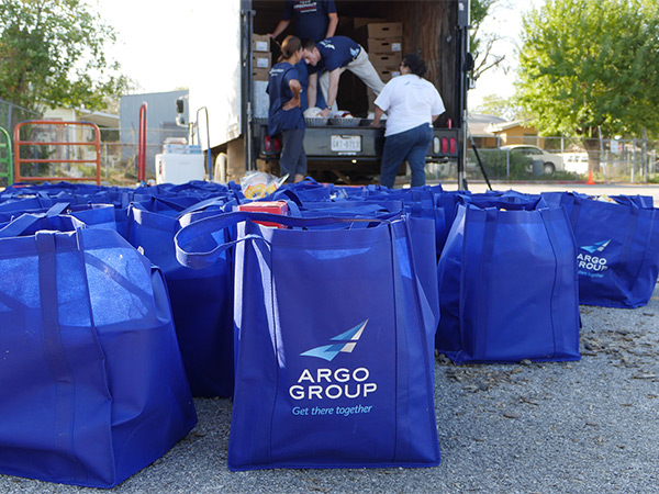A bag filled with food and Argo employees unloading a truck in the background