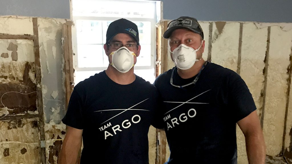 Two men wearing masks during interior house demolition