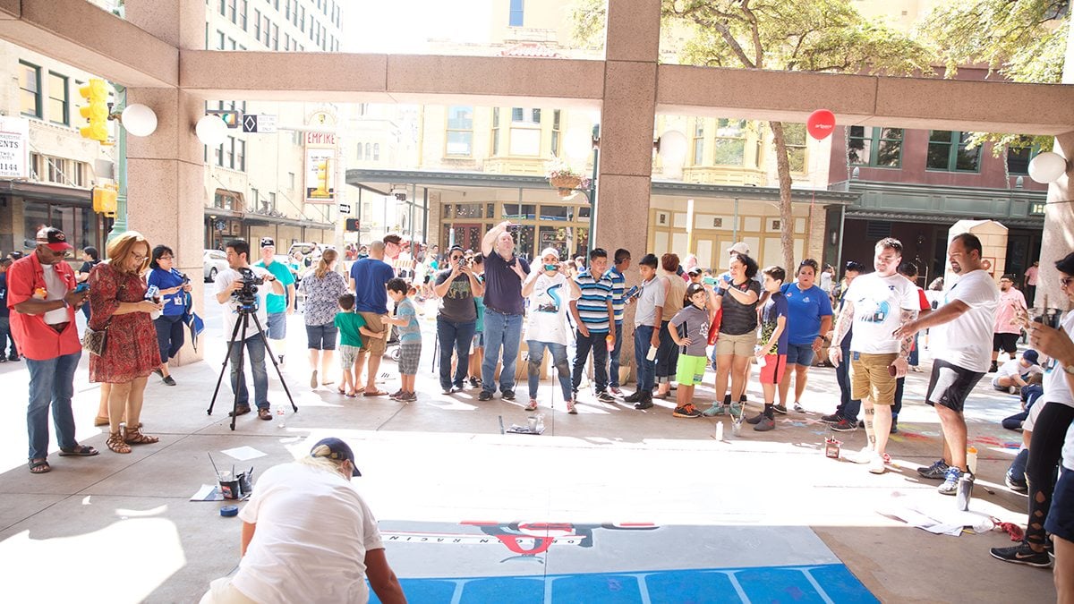 Onlookers examine sidewalk chalk art in front of Argo Group building during Chalk It Up in San Antonio