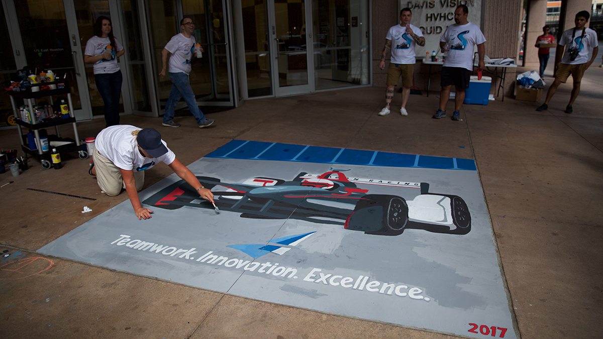 Man puts finishing touches on sidewalk chalk art in front of Argo Group building in San Antonio