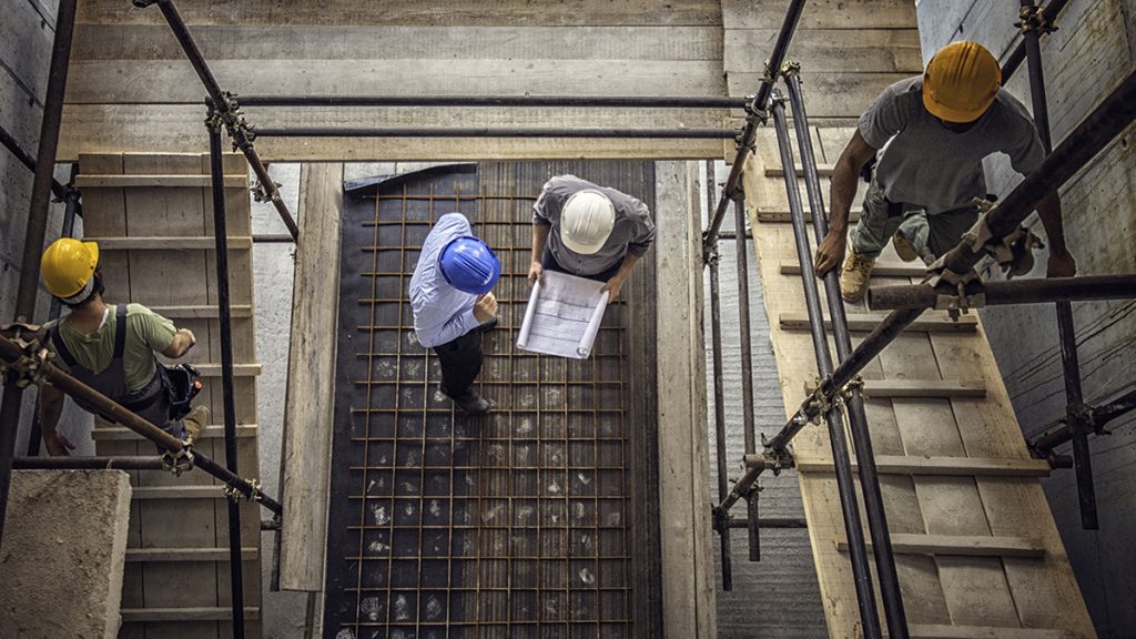 Construction workers and architects at a construction site viewed from above