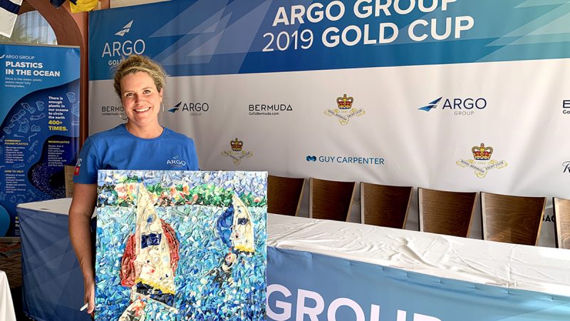 Woman displaying recycled plastic art at Argo Group Gold Cup beach cleanup