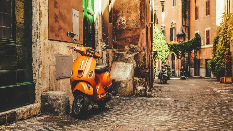 Vespa scooters parked in quaint Italian alleyway