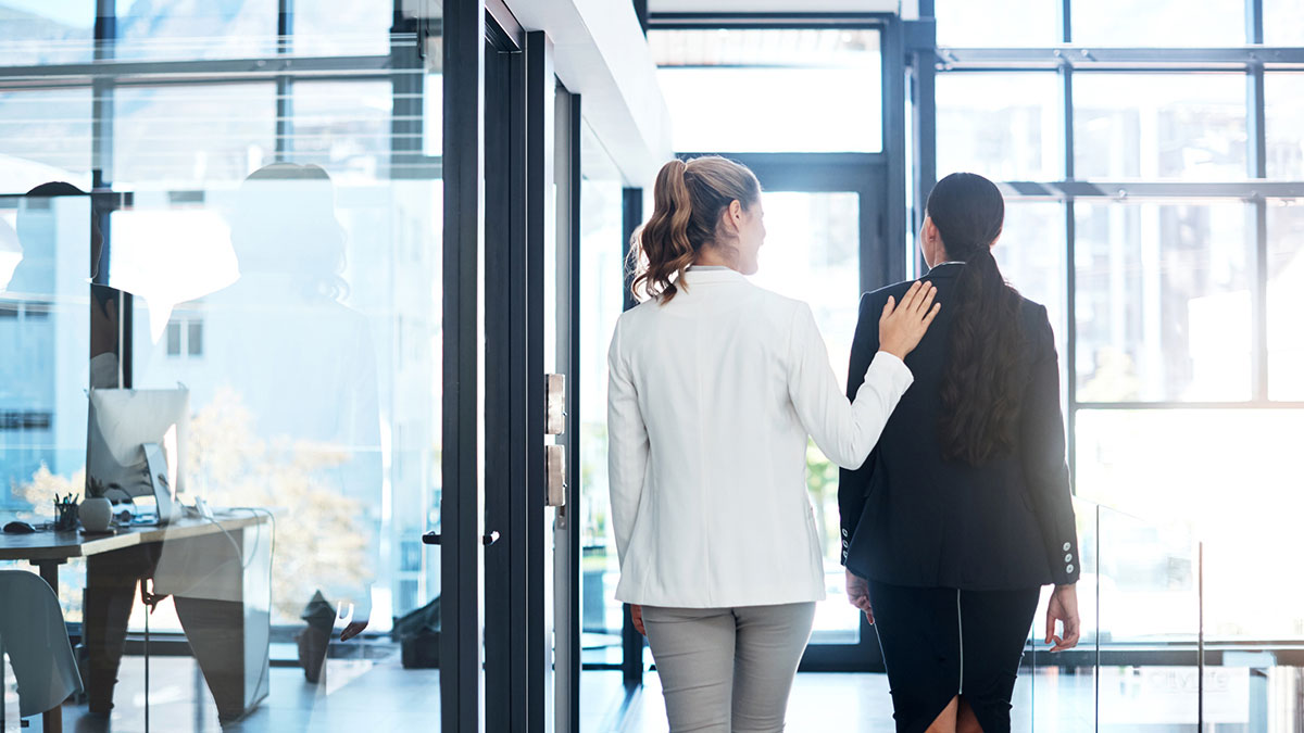 Two young professional women walking out of an office